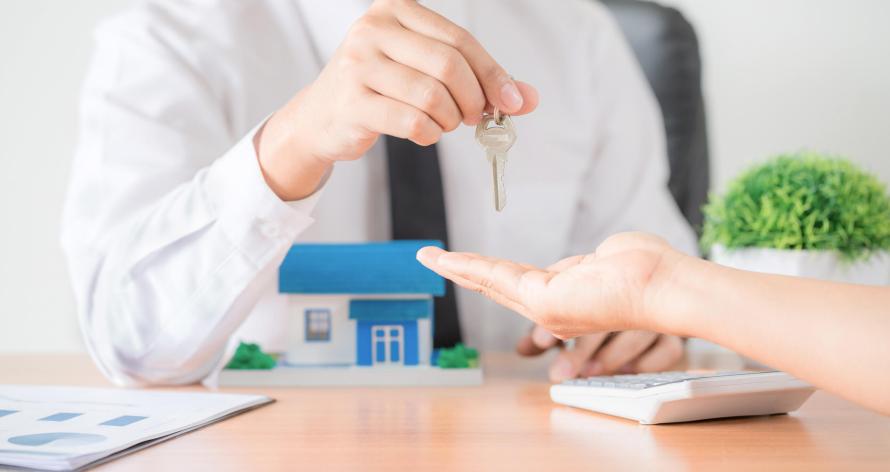 Realtor agent giving a key of apartment to new owner after signed lease agreement.
